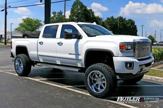 White lifted GMC truck with custom wheels and tires at Salgado Tires